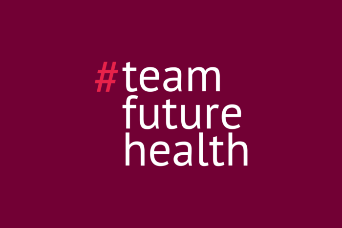 Logo der vitagroup #teamfuturehealth-Recruiting-Kampagne auf rotem Hintergrund.