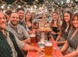 Das gesamte Innsiders Media Rosenheim Team an einem Biertisch auf dem Balkom im Flötzinger Festzelt beim Herbstfest 2024 in Rosenheim der "Wiesn" 2024