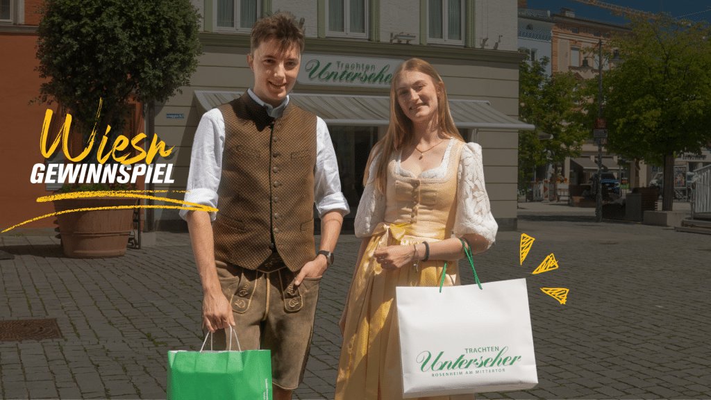 wiesn gewinnspiel innsiders Ein junger Mann in brauner Lederhose und eine junge Frau in einem gelben Dirndl